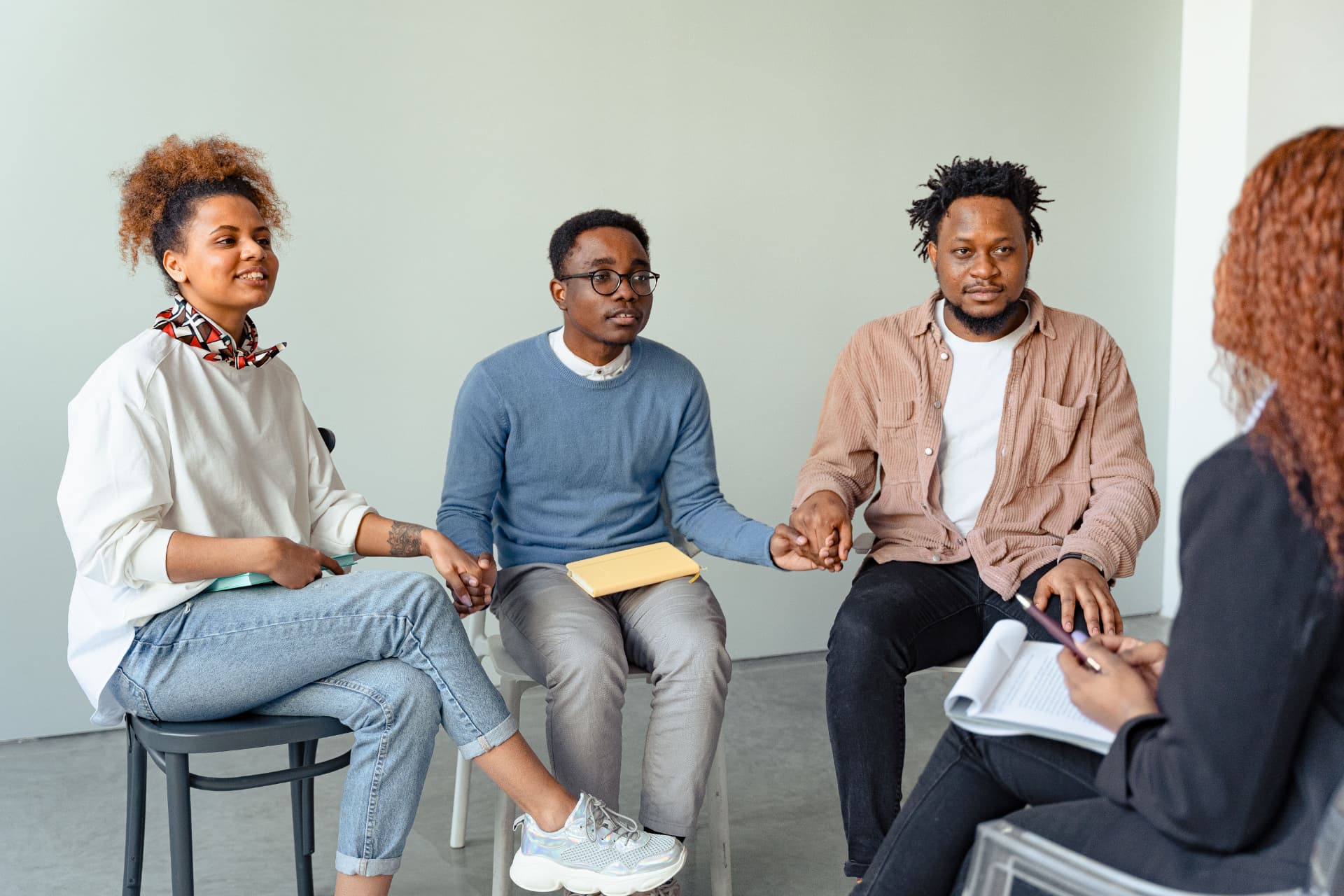 A diverse group of young adults sitting together in a supportive circle