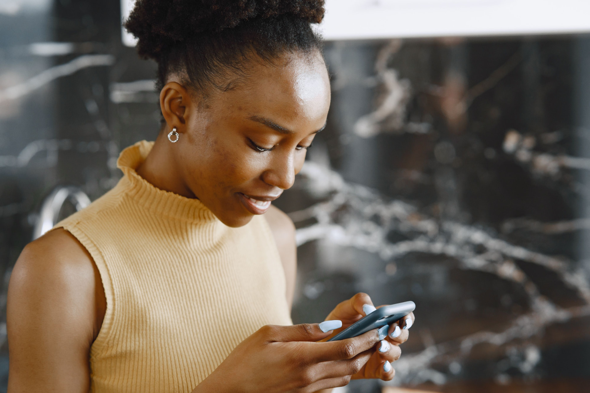 A woman smiling while using the Gimble app on her phone