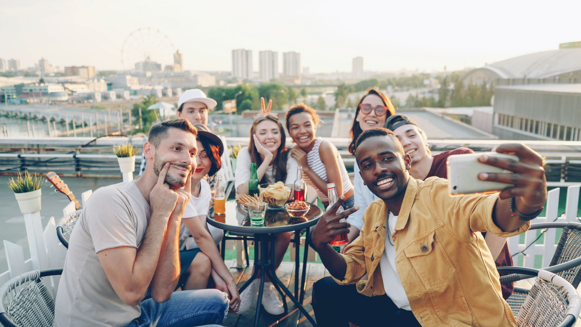 A diverse group of friends taking a selfie together on a rooftop
