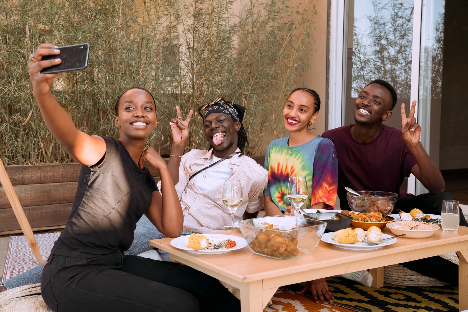 A group of friends enjoying a meal together and taking a selfie